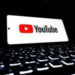 youtube logo on smartphone over keyboard