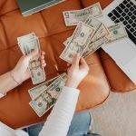 close up of woman counting dollar bills