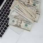 dollars scattered on laptop