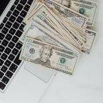 dollars scattered on laptop